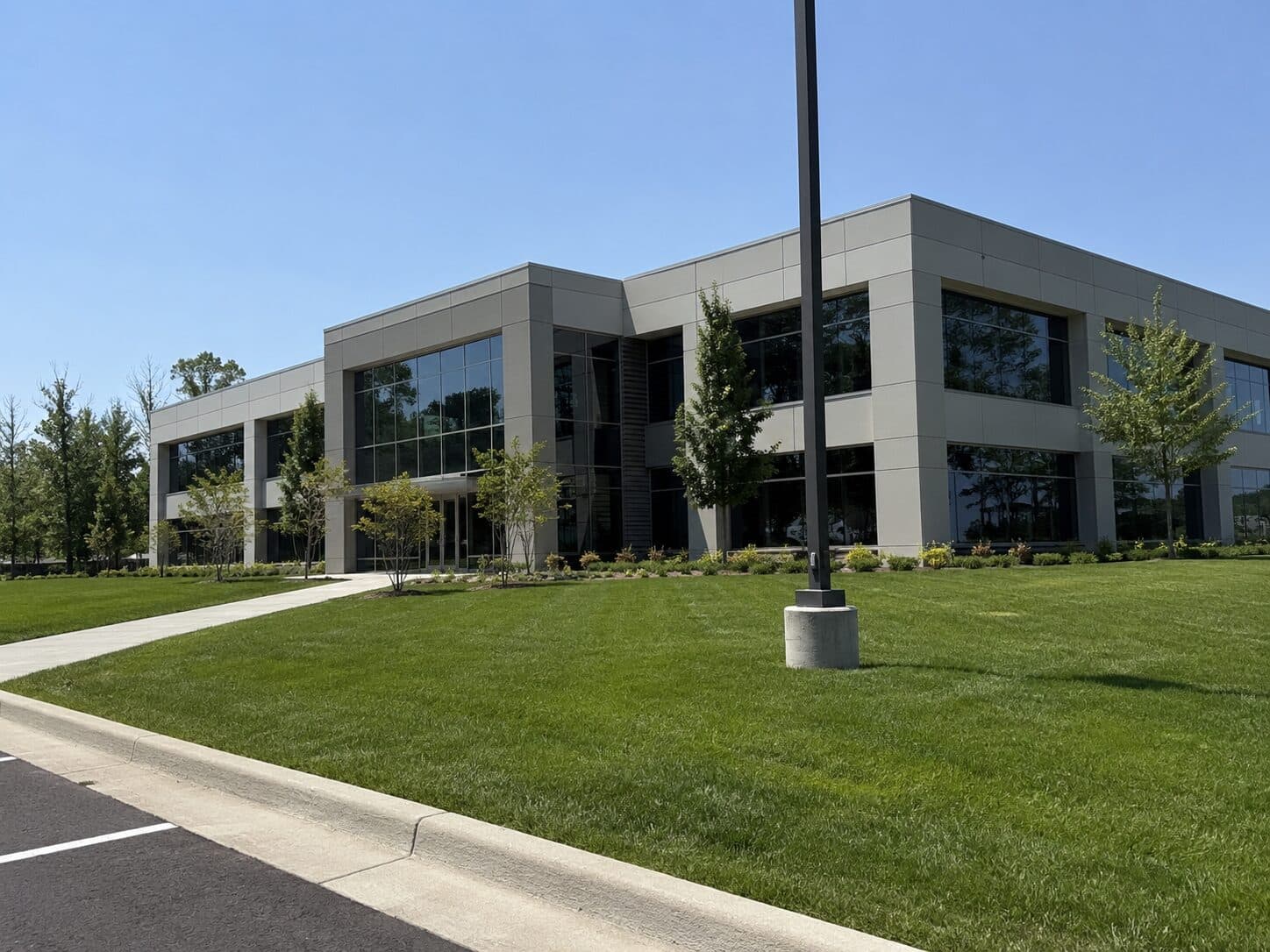 Modern office building bordered by a maintained lawn