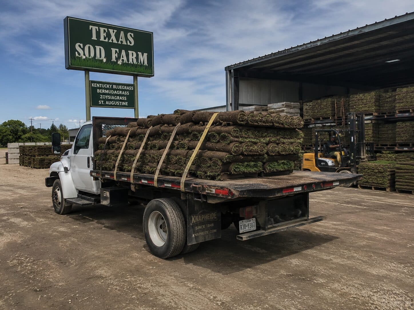 Sod farm operation with rolled turf and agricultural equipment